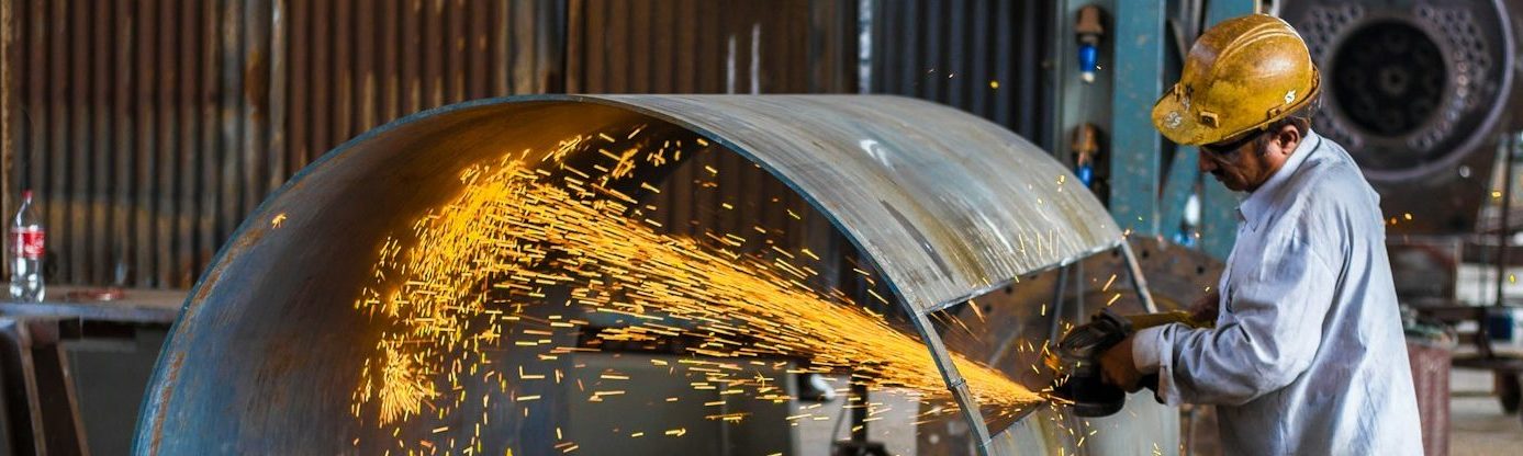 man wearing yellow hard hat holding angle grinder